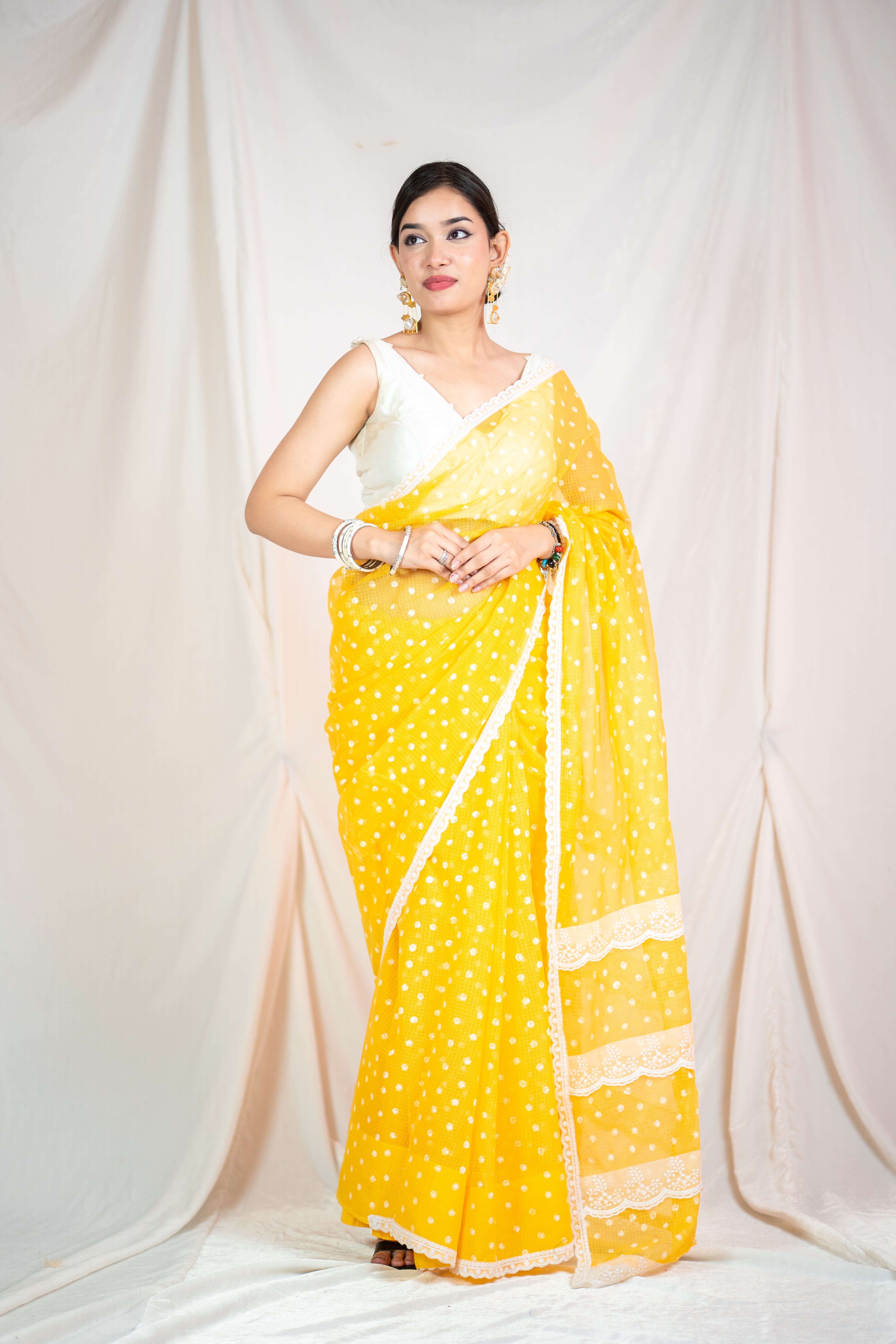 Yellow Kota Doria saree with white polka dots and lace detailing on edges.